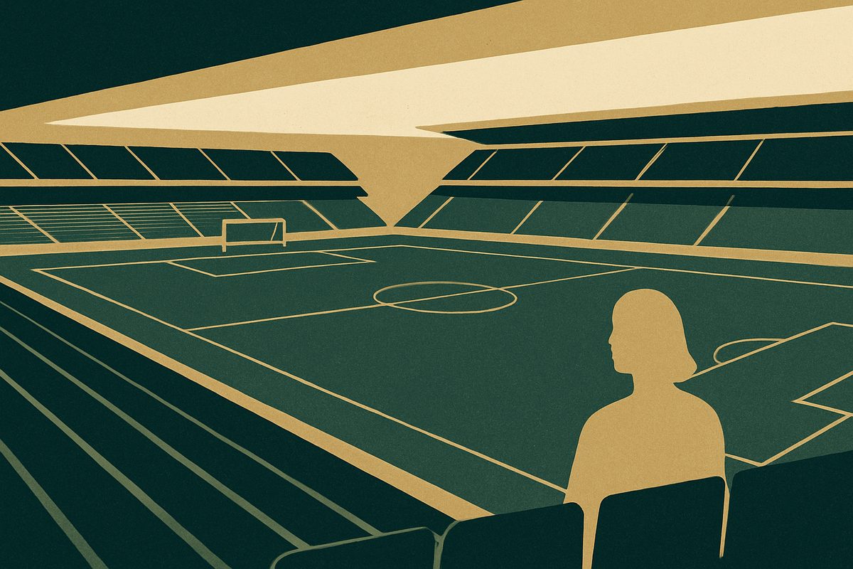 An empty stadium with a marked pitch and a single goal in view.